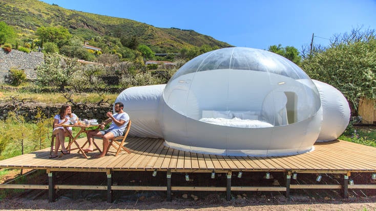 A couple sitting outside a holiday dome accommodation in the Canary Islands.