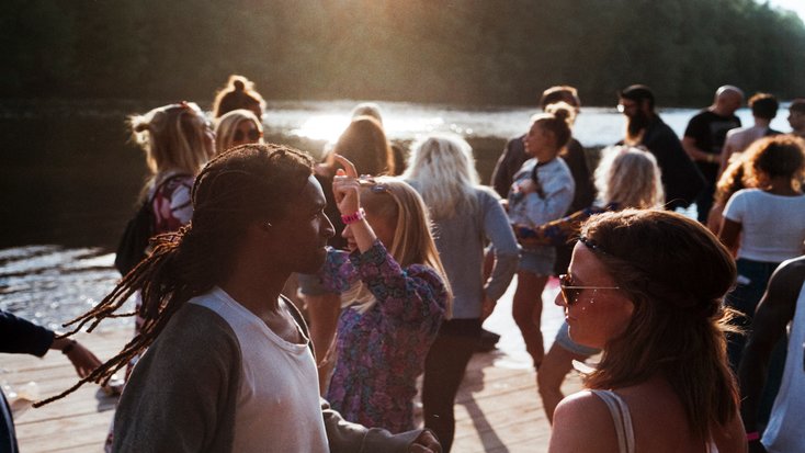 Group of people gathered on deck by water to celebrate Australia Day public holiday 2020 in the sunshine. 
