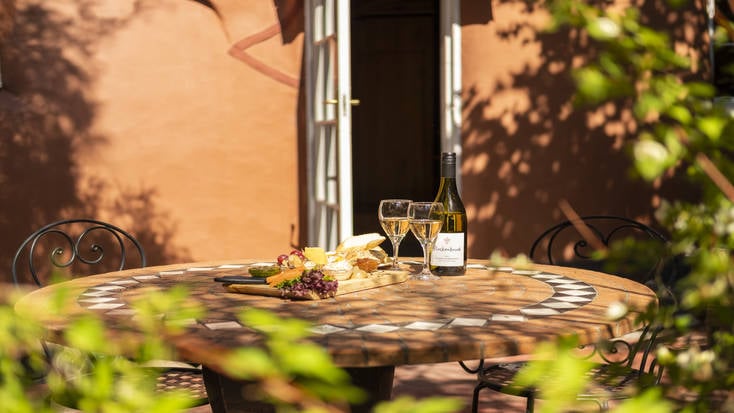 An outdoor dining area with wine and nibbles