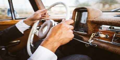Newlywed holding steering wheel in car on way to his romantic holiday for honeymoon.