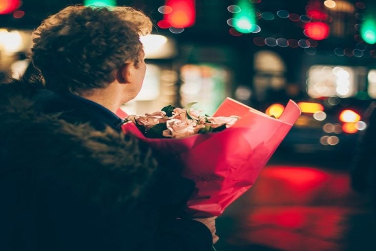 A man at night holding roses for Valentine's Day