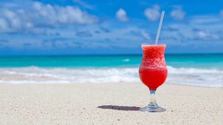 Relax by the sea with a cocktail when you book the best summer vacations