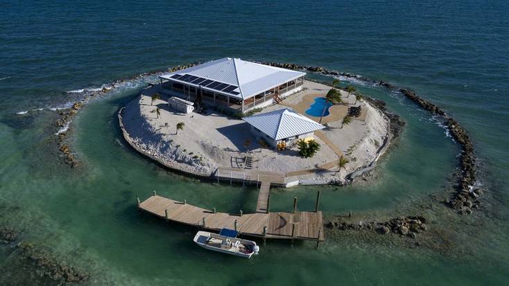 A private island rental with a boat, a pool, and a beach