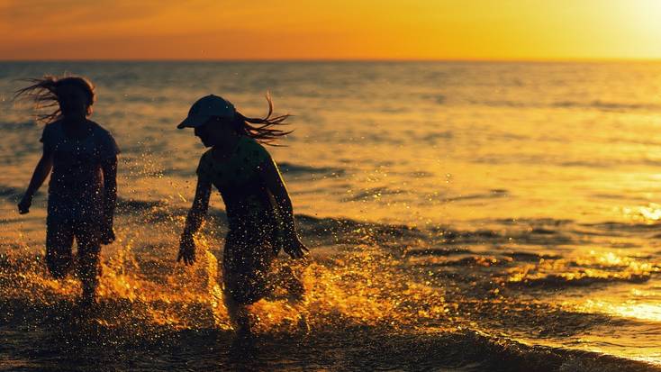 Two girls play in the ocean