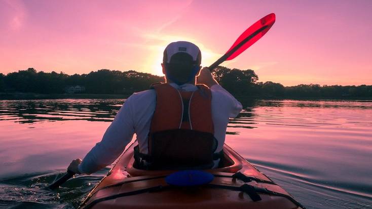 Kayaking on a lake at sunset is a great activity when you go glamping in fall