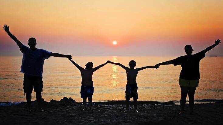 Family on the beach at sunset