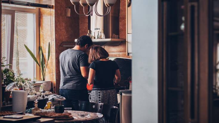 A couple cook a turkey together