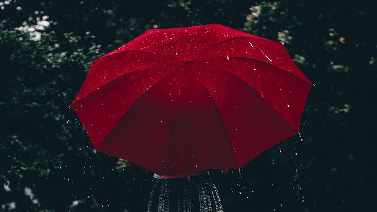 A woman with a red umbrella in the rain