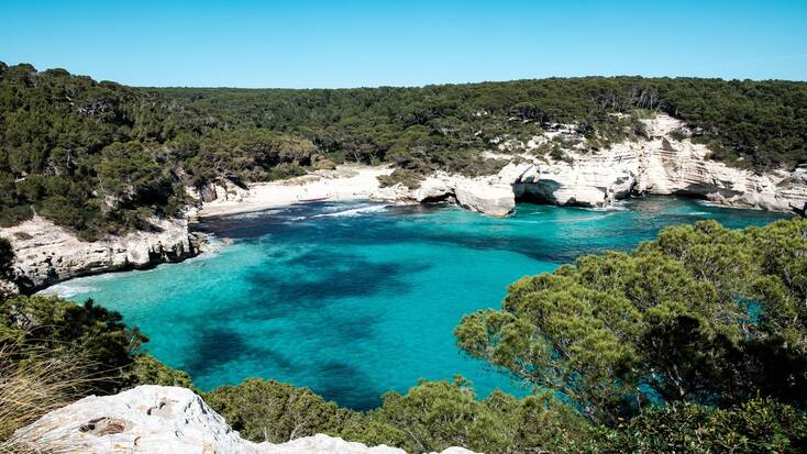 A view over a natural bay on Cala Mitjana, Menorca provides idyllic summer holidays