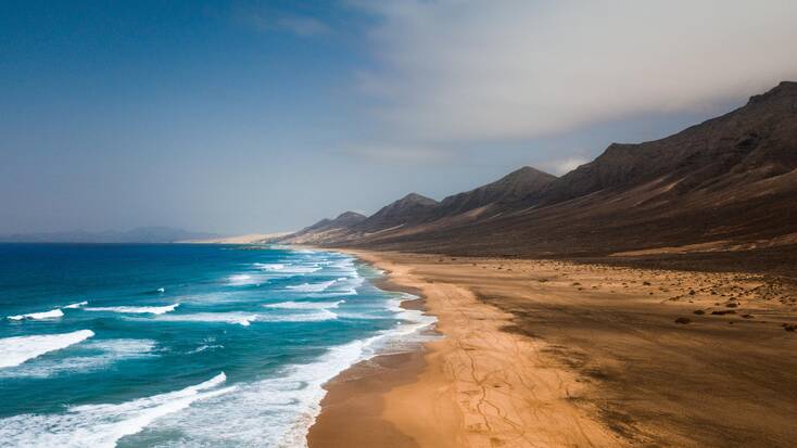 El Cofete Beach, deserted with crystal blue waters and stunning hills for the perfect summer holidays