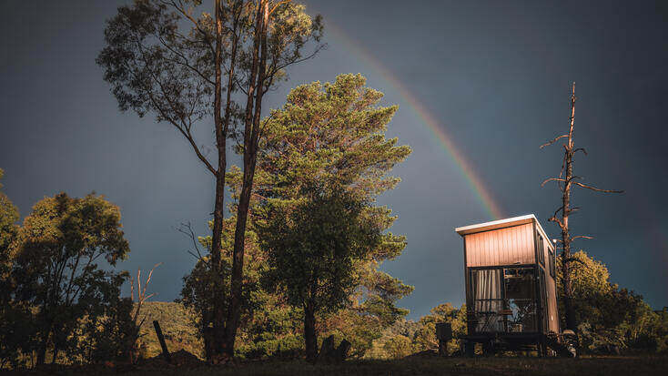 Experience glamping under a rainbow in an Australian tiny house rental.