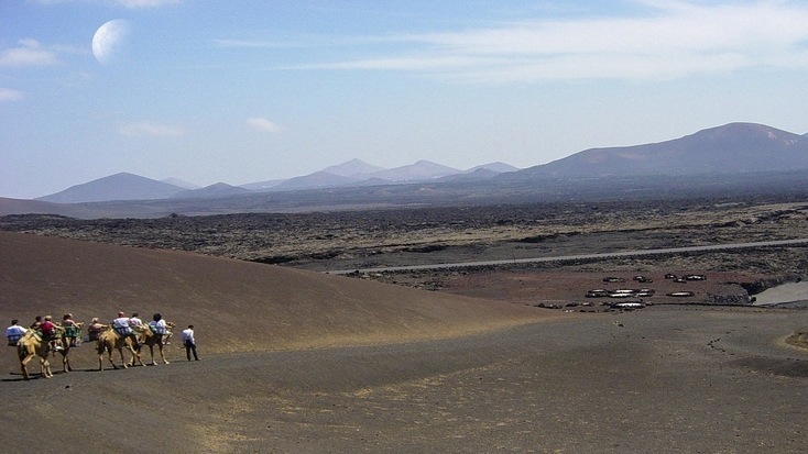 Tourists riding camels in the Timanfaya National Park