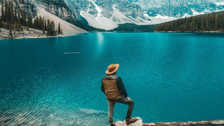 A hiker taking in views of a lake on his Victoria Day vacations in Canada