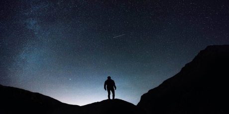 A man underneath the nightsky in one of the best stargazing locations