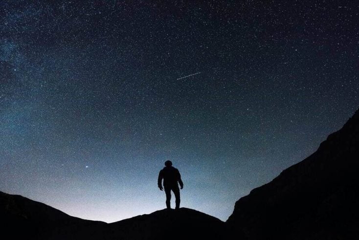 A man underneath the nightsky in one of the best stargazing locations