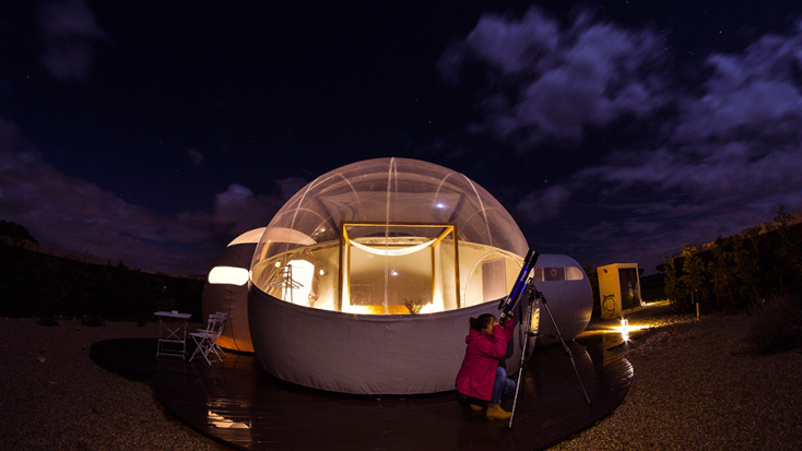 A guest star gazing using a telescope at the bubble dome luxury hotel in spain. 