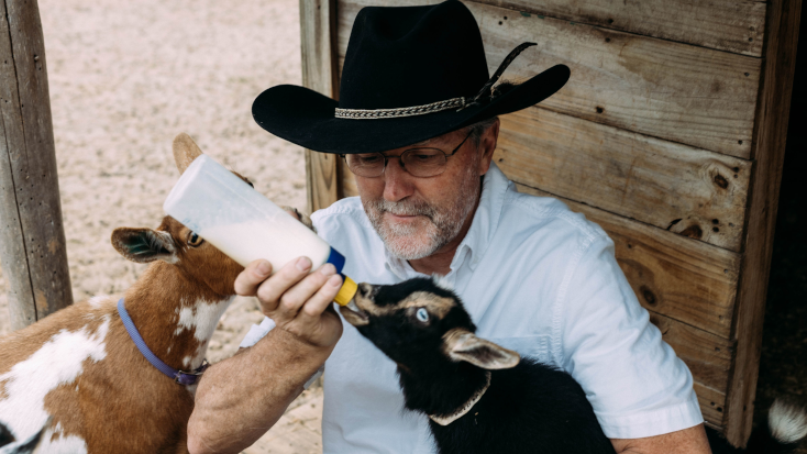Host of the Month for January 2022, Graham feeding his baby goats on his glamping farm in Texas