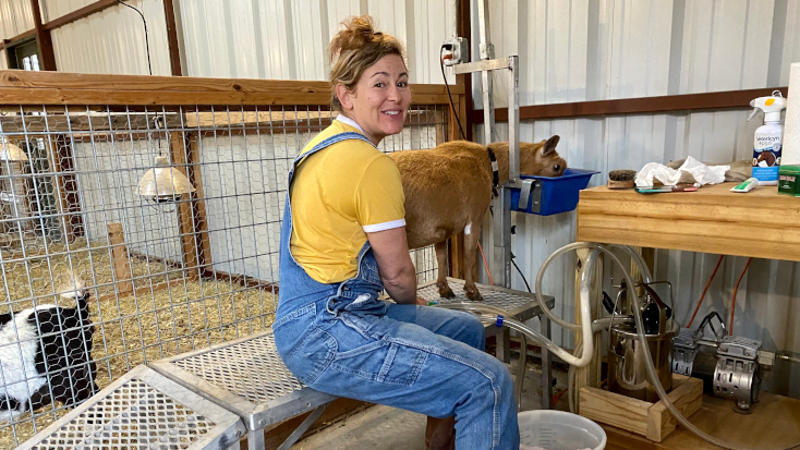 Karen, winner of Glamping Hub's Host of the Month for January 2022, caring for her goats at her farmstay near Austin. 