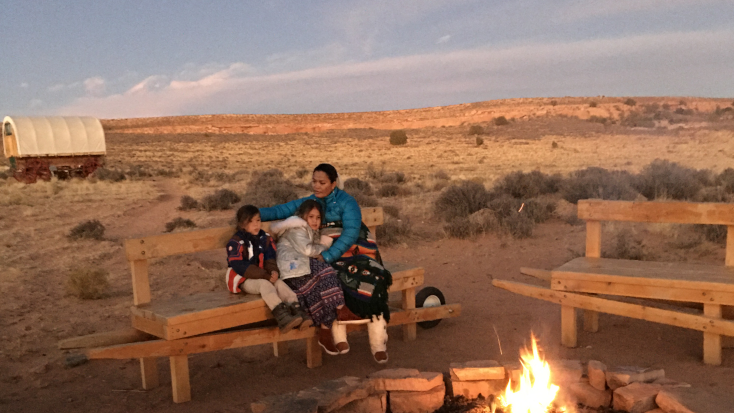 Baya and her family at their glamping resort in Arizona with their unique glamping wagon in the background. Glamping Hub's Host of the Month for February 2022.