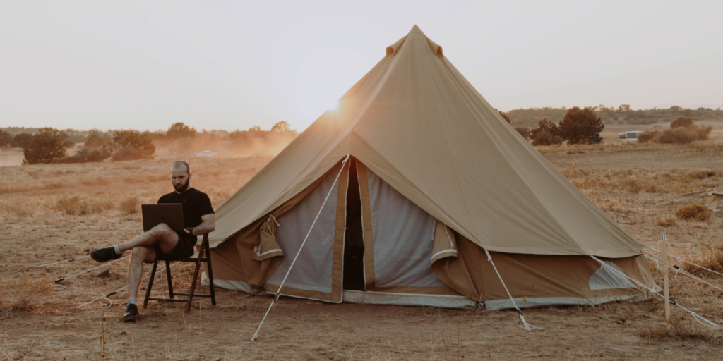 Expert guide: How to finance your glamping site - Landowner sitting outside bell tent 