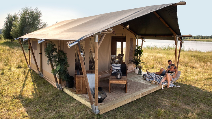 Safari Tent and couple enjoying at glamping experience at a campground