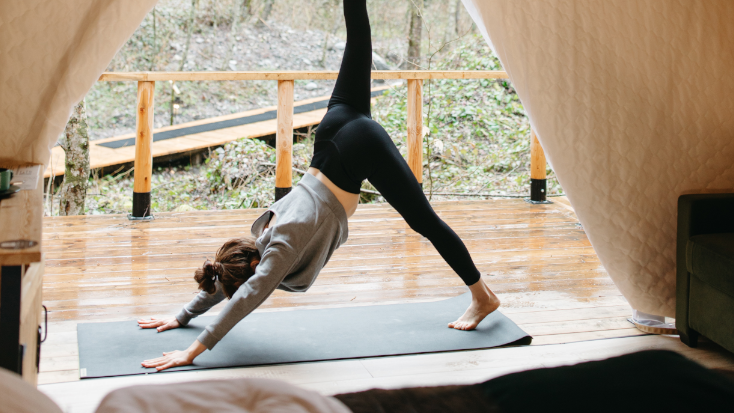 Yoga pose on a deck outside a safari tent