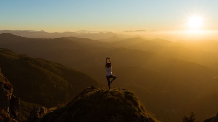 yoga pose on mountain top at sunset