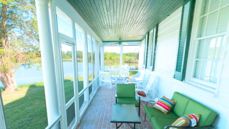 Covered deck with green seating and lake view