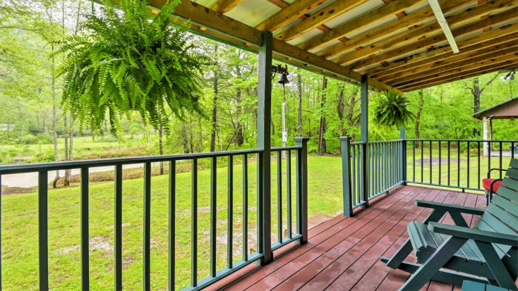 private dek with green deck chairs and river view and hanging ferns, Tennessee