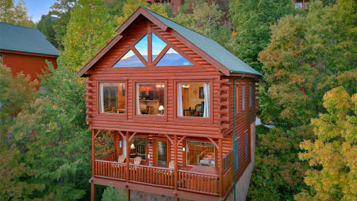 Luxury double level wood cabin with private deck, surrounded by trees