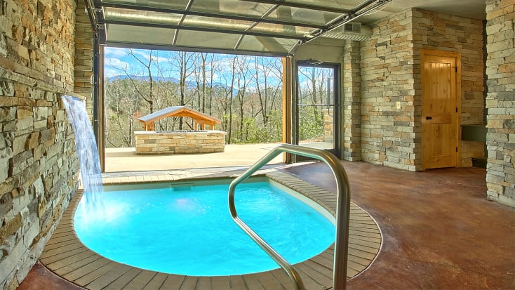 Indoor pool with view of private fire pit and Smoky Mountains