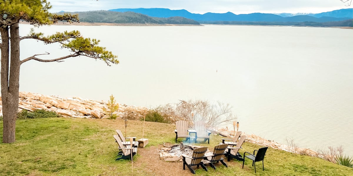 Lakeside fire pit with deck chairs and mountain view