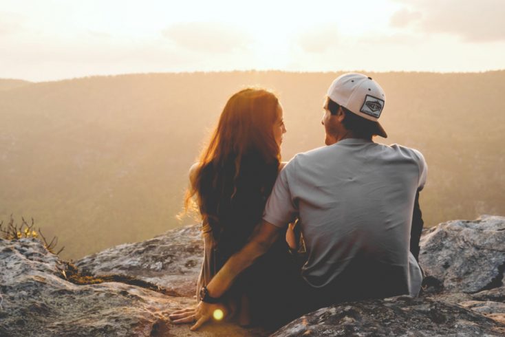 Couple watching the sunset over a mountain